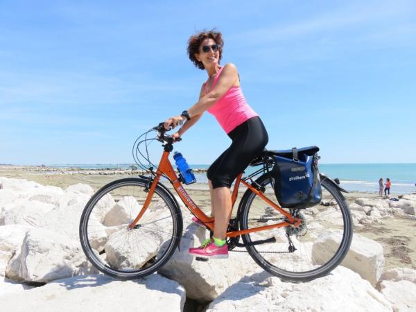 Radfaher am Sandstrand am Mittelmeer mit weien Ufersteinen