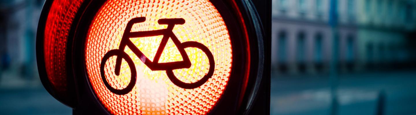 Red traffic light with bicycle sign with urban buildings in blurred background